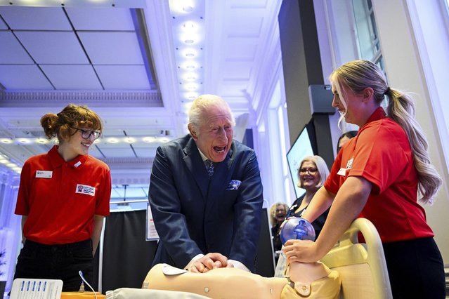 Britain's King Charles III performs CPR on a medical test mannequin as he attends a celebration for the 1,000th RCN King's Nursing Cadet at the Royal College of Nursing in London, Tuesday,, March 11, 2025. (Photo by Jaimi Joy/Pool Photo via AP Photo)