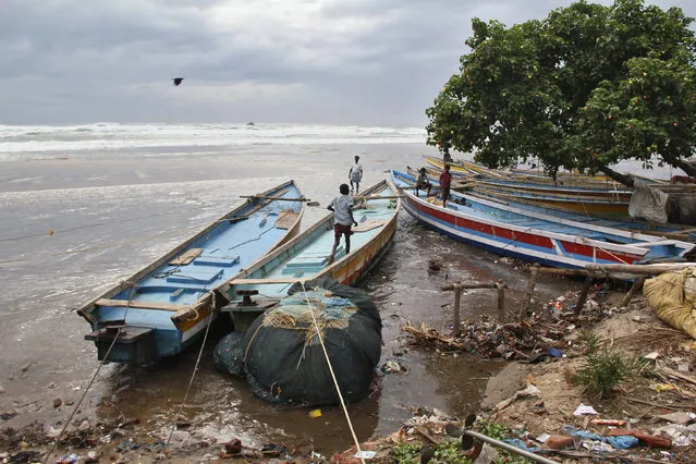 Boys walk on fishing boats by the shore before being evacuated, at Visakhapatnam district in Andhra Pradesh October 11, 2014. (Photo by R. Narendra/Reuters)