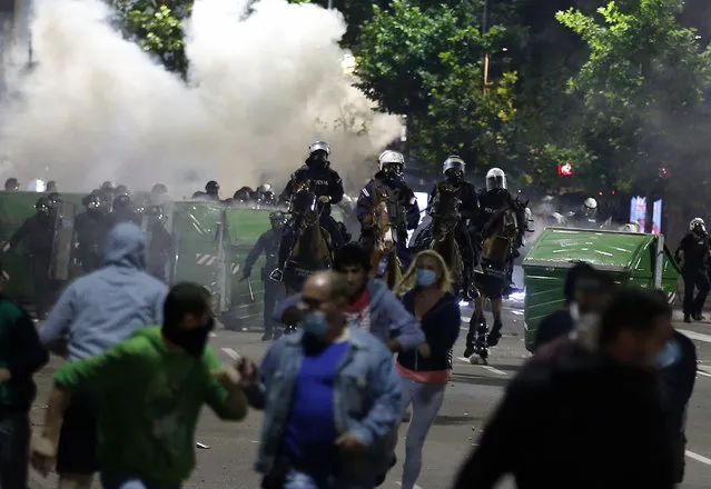 Sebian police officers disperse protesters in front of Serbian parliament building in Belgrade, Serbia, Wednesday, July 8, 2020. Thousands of people protested the Serbian president's announcement that a lockdown will be reintroduced after the Balkan country reported its highest single-day death toll from the coronavirus Tuesday. (Photo by Darko Vojinovic/AP Photo)