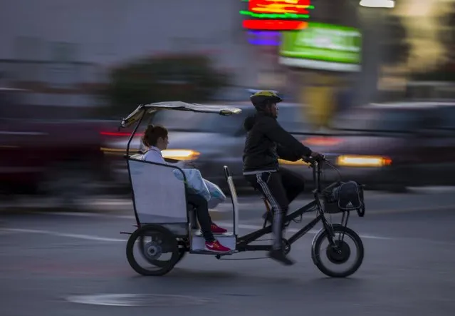 A woman rides a pedicab in the border town of San Ysidro, California September 2 2015. (Photo by Mike Blake/Reuters)