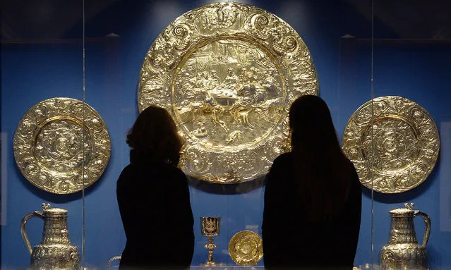 Two gallery assistants pose with a silver gilt altar dish (circa 1660) in The Queen's Gallery at Buckingham Palace on December 7, 2017 in London, England. The items are part of the new “Charles II: Art & Power” exhibition, which explores his use of art to reinforce his legitimacy and authority as monarch. The exhibition runs from 8 December 2017 to 12 May 2018. (Photo by John Stillwell/PA Wire)