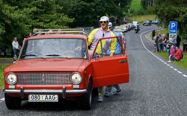 A man gets into a Lada car during a parade for the 50th anniversary of the brand in Varbuse, Estonia on July 25, 2020. (Photo by Janis Laizans/Reuters)