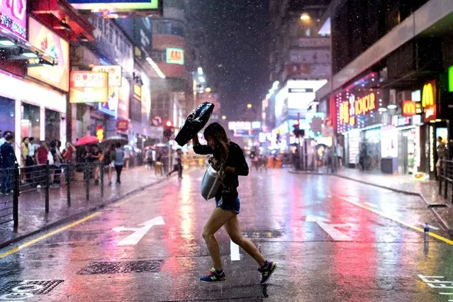 A woman runs through the rain on a road barricaded by pro-democracy protesters in the Mongkok district of Hong Kong on October 22, 2014. Hong Kong student leaders said on October 22 they may shun further talks with the government, accusing it of failing to make any meaningful offers to end weeks of mass pro-democracy rallies and roadblocks. (Photo by Alex Ogle/AFP Photo)