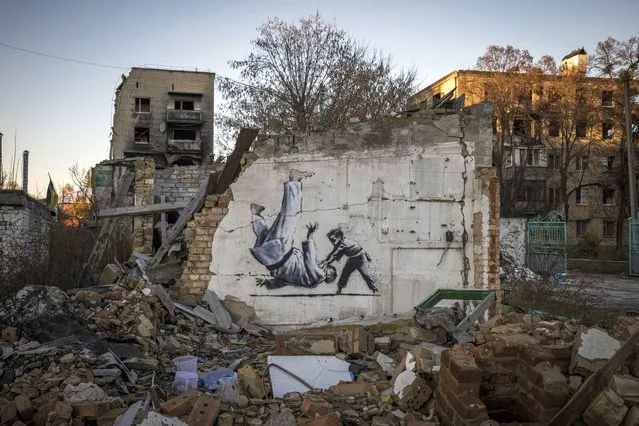 Graffiti of a child throwing a man on the floor in judo clothing is seen on a wall amid damaged buildings in Borodyanka on November 09, 2022 in Kyiv Region, Ukraine. Borodyanka was hit particularly hard by Russian airstrikes in the first few weeks of the conflict. Electricity and heating outages across Ukraine caused by missile and drone strikes to energy infrastructure have added urgency to preparations for winter. (Photo by Ed Ram/Getty Images)