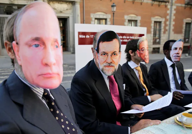 (L-R) Protesters wearing masks depicting Russian President Vladimir Putin, Spain's Prime Minister Mariano Rajoy, European Commission President Jean Claude Juncker and U.S. President Barack Obama demand protection of the rights of refugees, migrants and displaced people, ahead of the world leaders meeting about the global refugee crisis next week, in front of Spain's foreign ministry in Madrid, Spain, September 16, 2016. The banner reads “More then 17 persons die every day across the world trying to reach a dignified life”. (Photo by Andrea Comas/Reuters)