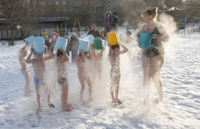 Children pour cold water on themselves under the control of fitness coach Margarita Filimonova (R) at local kindergarten number 317, with the air temperature at about minus 23 degrees Celsius (minus 9.4 degrees Fahrenheit), in Russia's Siberian city of Krasnoyarsk, February 5, 2013. (Photo by Ilya Naymushin/Reuters)