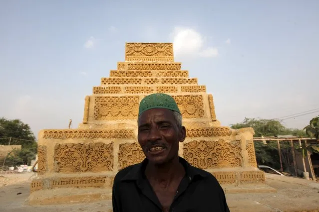 A Sheedi man poses for a photograph beside an old grave while visiting the shrine of Hasan-al-Maroof Sultan Manghopir, better known as the crocodile shrine, on the outskirts of Karachi, Pakistan October 11, 2015. (Photo by Akhtar Soomro/Reuters)