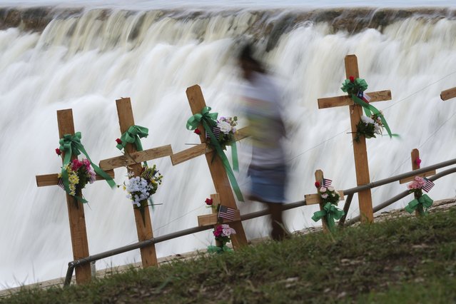 A girl runs past crosses at a makeshift memorial for Guadalupe River flood victims in Kerrville, Texas, on Sunday, July 13, 2025. (Photo by Eric Gay/AP Photo)
