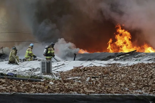 Firefighters battle a fire at Guryong village in Seoul, South Korea, Friday, January 20, 2023. About 500 South Koreans were forced to flee their homes after a fire spread through a low-income neighborhood in southern Seoul on Friday morning and destroyed dozens of homes. (Photo by Baek Dong-hyun/Newsis via AP Photo)