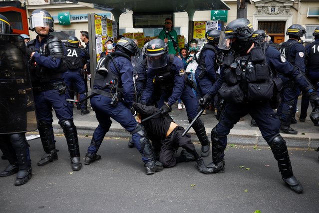 Riot police gather around a demonstrator who is being held on the ground during the traditional May Day labour union march in Paris, France on May 1, 2024. (Photo by Sarah Meyssonnier/Reuters)