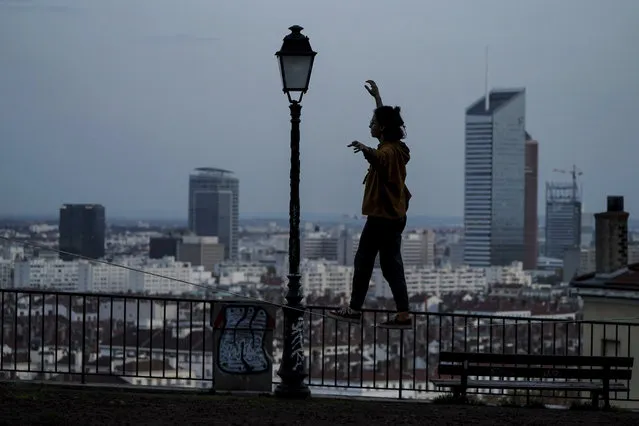A woman balances on a slackline on a hill above Lyon, central France, Friday, November 6, 2020. In France, which is in a monthlong partial lockdown to stop fast-rising virus hospitalizations and deaths, restaurants and non-essential stores are closed for a month, but schools remain open and there are several other exceptions to the lockdown. (Photo by Laurent Cipriani/AP Photo)