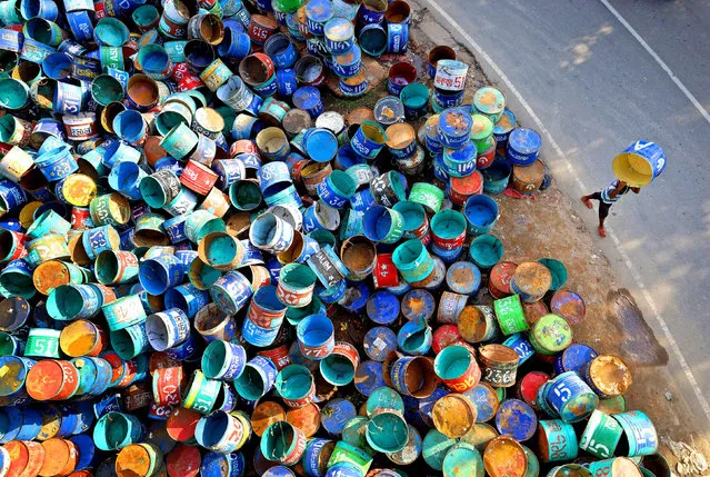 Workers gather together hundreds of colourful barrels used to transport fish near a wholesale market in Rangamati, Bangladesh on February 28, 2023. (Photo by Syed Mahabubul Kader/Solent News & Photo Agency)