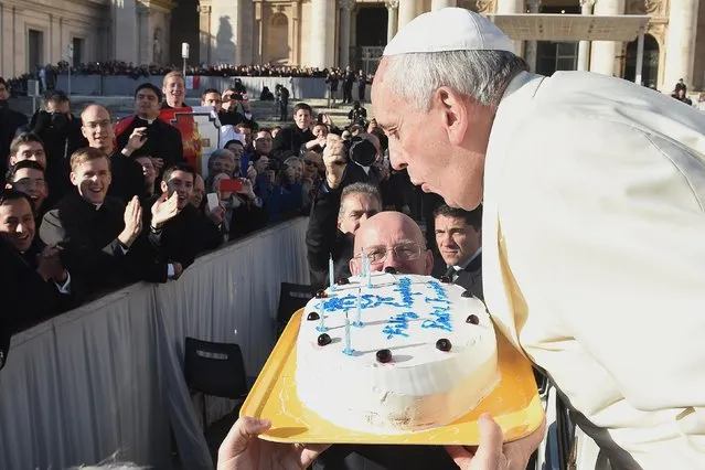 Pope Francis, who celebrates his 78th birthday, blows out candles on a cake as he arrives to lead his general audience at the Vatican, December 17, 2014. (Photo by Osservatore Romano/Reuters)