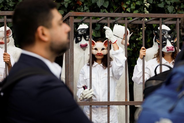 Masked Greenpeace activists in cages stage a protest as delegates arrive at a U.N. conference, joining multiple groups to call for a just transition from industrial agriculture, outside the Food and Agriculture Organization (FAO) headquarters, in Rome, Italy on September 29, 2025. (Photo by Remo Casilli/Reuters)