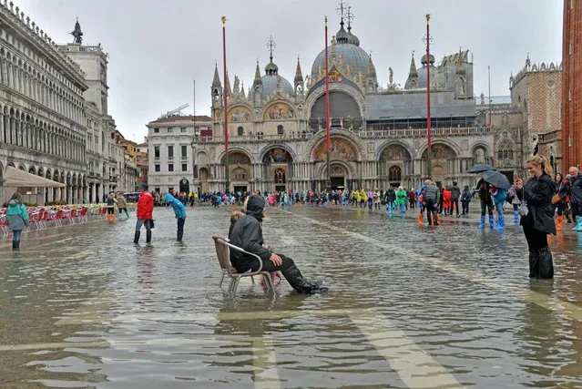 A man sists in the high water on the Piazza San Marco in Venice, Italy, 14 October 2016. Venice saw its first “acqua alta” of the year with water 93 cm above sea level causing low-lying areas of the lagoon city to be flooded. (Photo by Andrea Merola/EPA)