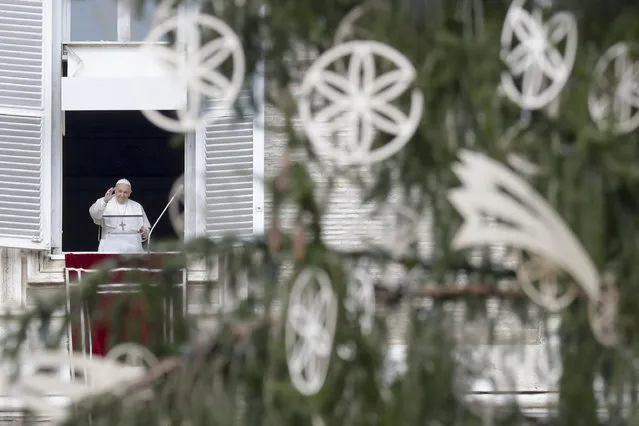 Pope Francis, framed by the Vatican Christmas tree, delivers his blessing as he recites the Angelus noon prayer from the window of his studio overlooking St.Peter's Square, on the Immaculate Conception day, at the Vatican, Tuesday, December 8, 2020. (Photo by Andrew Medichini/AP Photo)