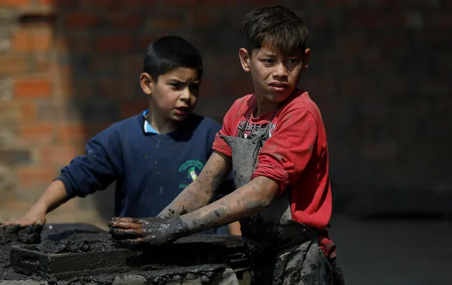 Mauri, 11, left, and Cesar, 13, work at a clay brick factory in Tobati, Paraguay, Friday, September 4, 2020. The boys have been working at the factory, run by Mauri's family, since before schools stopped operating in March amid the COVID-19 pandemic. (Photo by Jorge Saenz/AP Photo)