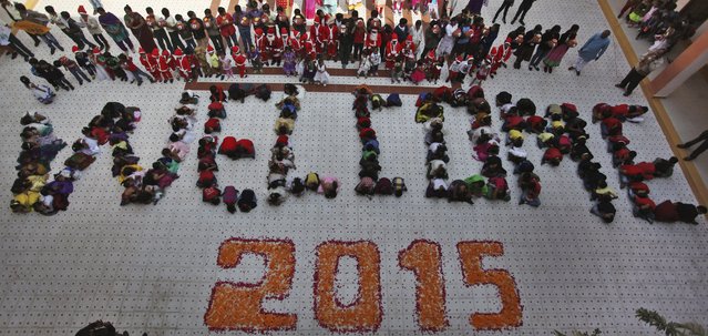 Indian students form numbers representing the year 2015 during a function to welcome the New Year at a school in Ahmadabad, India, Wednesday, December 31, 2014. (Photo by Ajit Solanki/AP Photo)