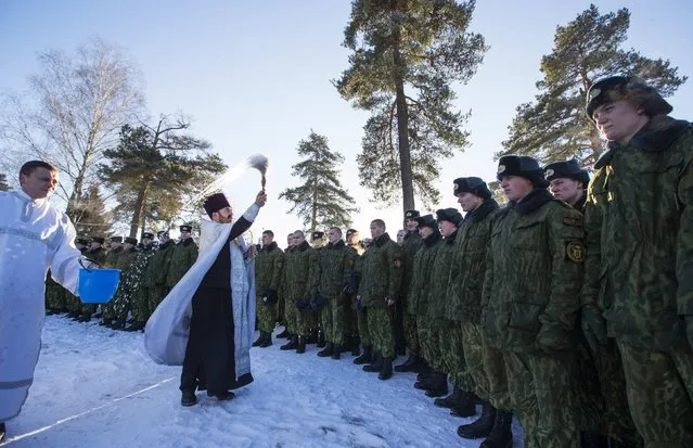 Servicemen of the Belarussian Interior Ministry's special force take part in a service near Orthodox church at a military base in Minsk January 7, 2015. Most Orthodox Christians celebrate Christmas according to the Julian calendar on January 7, two weeks after most western Christian churches that abide by the Gregorian calendar. (Photo by Vasily Fedosenko/Reuters)
