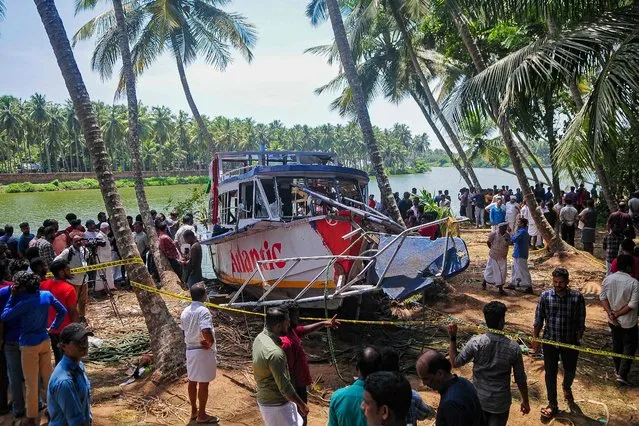 Onlookers gather near the site of a boat accident in Tanur, in Malappuram district on May 8, 2023. At least 22 people died when a double-decker tourist boat capsized in India's southern state of Kerala, officials said. (Photo by AFP Photo/Stringer)