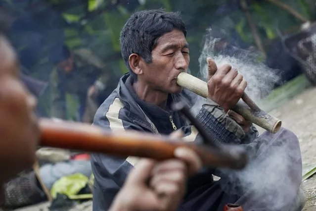 Men smoke opium from traditional pipes made out of bamboo at a hunting base camp in an opium field during a hunting trip between Donhe and Lahe township in the Naga Self-Administered Zone in northwest Myanmar December 27, 2014. The opium is harvested from poppy fields cultivated nearby and is mostly kept for local consumption, while some is traded for goods such as clothing or household items. (Photo by Soe Zeya Tun/Reuters)