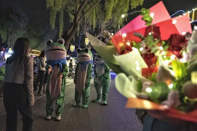 Visitors dressed as frogs walk along a popular street lined with bars, in Beijing, Friday, May 5, 2023. (Photo by Ng Han Guan/AP Photo)