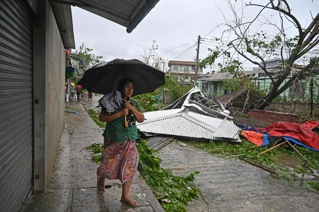 A local resident walks past the fallen trees after Cyclone Mocha's crashed ashore, in Kyauktaw in Myanmar's Rakhine state on May 14, 2023. (Photo by Sai Aung Main/AFP Photo)