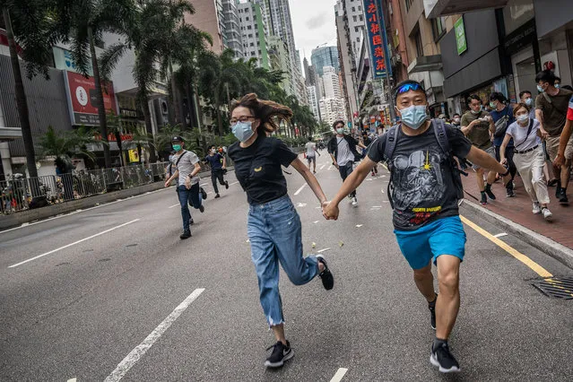 Protesters running away as police shot water cannon and pepper bullets at the crowd in Hong Kong, China on July 1, 2020. Thousands took to the streets of Hong Kong on the 23rd anniversary of the handover from Britain to China in defiance of police ban. The day also marks the first day of the implementation of the controversial national security law imposed by Beijing, which many seen as a blatant attack to human rights in the city. (Photo by Geovien So/SOPA Images/Rex Features/Shutterstock)