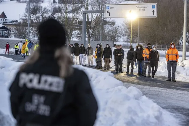 Numerous people wait in front of a Corona test station at the German-Czech Republic border in Furth im Wald, Germany, Monday, January 25, 2021. German police say hundreds of cars and pedestrians are lining up at border crossings along the Czech-German border after Germany declared the Czech Republic a high risk area in the pandemic meaning it requires proof a negative coronavirus test results before entry. (Photo by Armin Weigel/dpa via AP Photo)