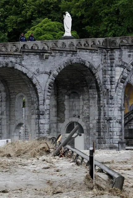 The sanctuary of Lourdes flooded, in Lourdes, southwestern France, Tuesday, June 18, 2013. French rescue services and police are evacuating hundreds of pilgrims from hotels threatened by floodwaters from a rain-swollen river in the Roman Catholic shrine town of Lourdes. (Photo by Bob Edme/AP Photo)