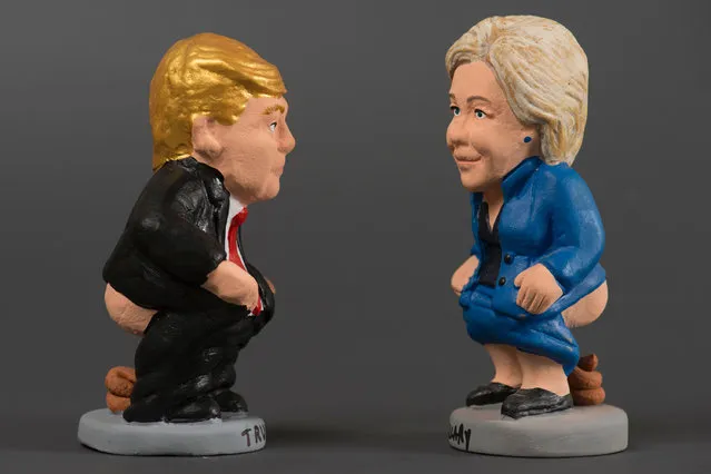 Ceramic figurines, called “caganers” (poopies), representing US Democratic presidential nominee Hillary Clinton (R) and  US Republican presidential nominee Donald Trump (L) are displayed at a factory in Torroella de montgri on November 4, 2016. Statuettes of well-known people defecating are a strong Christmas tradition in Northeastern Spanish region of Catalonia, dating back to the 18th century as Catalans hide “caganers” in Christmas Nativity scenes and invite friends to find them. The figures symbolize fertilization, hope and prosperity for the coming year. (Photo by Josep Lago/AFP Photo)