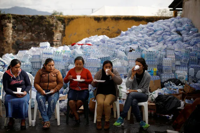 Women drink coffee at a collection centre at an area affected by the eruption of Fuego volcano in Alotenango, Guatemala on June 8, 2018. (Photo by Jose Cabezas/Reuters)