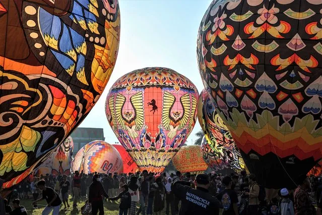 Visitors attend the balloon festival on the Eid al-Fitr holiday at Ronggolawe Stadion on April 23, 2023, in Wonosobo, Central Java, Indonesia. Javanese people fly giant hot air balloons during Eid, which has long been a tradition of the Wonosobo regency. (Photo by Garry Lotulung/Anadolu Agency via Getty Images)