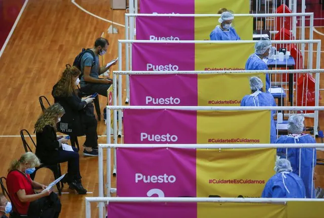 People wait to receive doses of Russia's Sputnik V vaccine against the coronavirus disease (COVID-19) at the basket ball court at the River Plate stadium, in Buenos Aires, Argentina on February 3, 2021. (Photo by Matias Baglietto/Reuters)