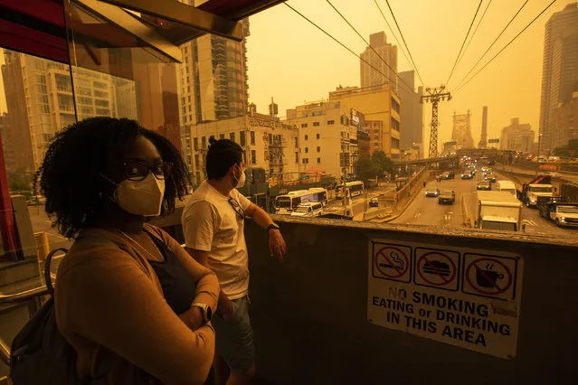 People wear masks as they wait for the tramway to Roosevelt Island as smoke from Canadian wildfires casts a haze over the area on June 7, 2023 in New York City. Air pollution alerts were issued across the United States due to smoke from wildfires that have been burning in Canada for weeks. (Photo by Eduardo Munoz Alvarez/Getty Images)