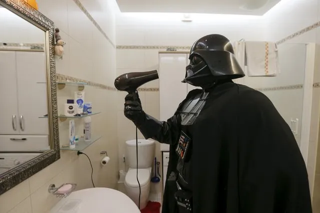 Darth Mykolaiovych Vader, who is dressed as the 'Star Wars' character Darth Vader, poses for a picture as he dries his mask and helmet with a hairdryer in the bathroom of his apartments in Odessa, Ukraine, December 2, 2015. (Photo by Valentyn Ogirenko/Reuters)