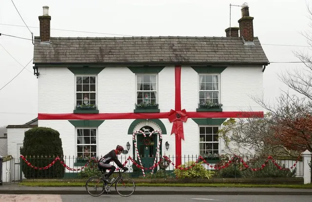 A man cycles past a house decorated as a Christmas present in Scholar Green northern Britain, December 15, 2015. (Photo by Phil Noble/Reuters)