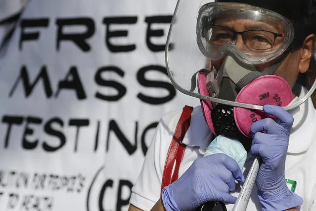 A health worker wearing protective gear talks during a rally at the Philippine Heart Center in Quezon city, Philippines, Friday January 29, 2021. Protesters said that it has been almost one year since the first reported case of the coronavirus in the country and they are still demanding the government for free mass testing, free vaccines and paid quarantine leave for workers. (Photo by Aaron Favila/AP Photo)