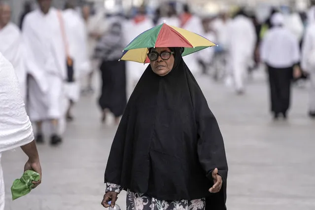 Sudanese pilgrim Um Safaa, who came from Port Sudan for the Hajj, walk outside the Grand Mosque, during the annual hajj pilgrimage, in Mecca, Saudi Arabia, Saturday, June 24, 2023. Muslim pilgrims who converging on Saudi Arabia's holy city of Mecca for the largest hajj since the coronavirus pandemic severely curtailed access to one of Islam's five pillars. (Photo by Amr Nabil/AP Photo)