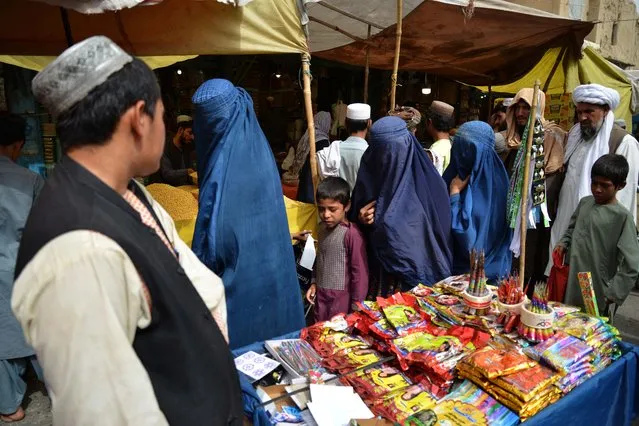 People throng a market in Kandahar on June 27, 2023, ahead of Muslim festival of Eid al-Adha. (Photo by Sanaullah Seiam/AFP Photo)