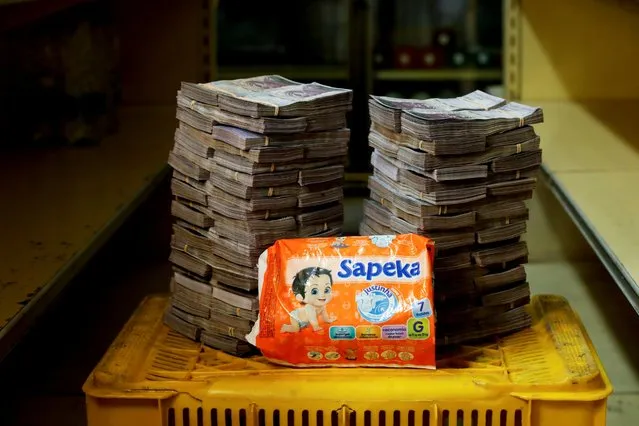 A package of diapers is pictured next to 8,000,000 bolivars, its price and the equivalent of 1.22 USD, at a mini-market in Caracas, Venezuela August 16, 2018. It was the going price at an informal market in the low-income neighborhood of Catia. (Photo by Carlos Garcia Rawlins/Reuters)