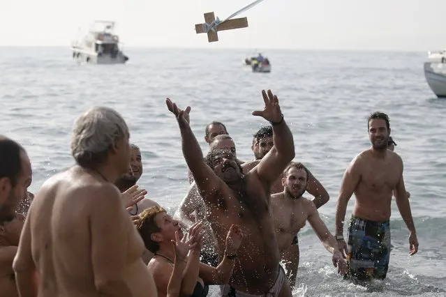 Orthodox faithful jump to catch a wooden crucifix thrown by Archbishop of Athens and All Greece, Ieronimos (not pictured) during Epiphany day celebrations in the southern suburb of Faliro in Athens, Greece, January 6, 2016. (Photo by Alkis Konstantinidis/Reuters)