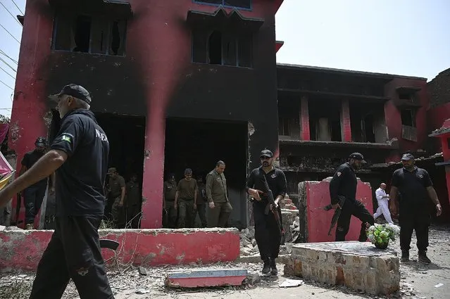 Police officials inspect a burnt Salvation Army church in Jaranwala on the outskirts of Faisalabad on August 17, 2023, a day after an attack by Muslim men following spread allegations that Christians had desecrated the Koran. Police were guarding a Christian neighbourhood in central Pakistan on August 17, after hundreds of Muslim men rampaged through its streets setting fire to churches and ransacking homes over accusations of blasphemy a day earlier. (Photo by Aamir Qureshi/AFP Photo)