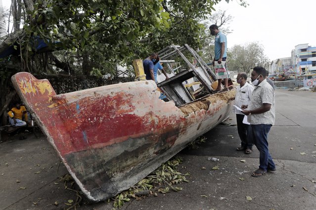 Fishermen inspect a fishing boat wrecked in a powerful storm that lashed the region this week in Mumbai, Maharashtra state, India, Thursday, May 20, 2021. Cyclone Tauktae packed sustained winds of up to 210 kilometers (130 miles) per hour, leaving more than 50 dead in Gujarat and Maharashtra states. (Photo by Rajanish Kakade/AP Photo)