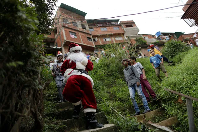 Santa Claus walks during a visit to residents of the slum of Petare in Caracas, Venezuela, December 11, 2016. (Photo by Ueslei Marcelino/Reuters)