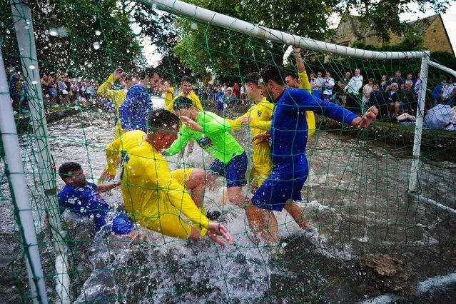 Footballers from Bourton Rovers fight for the ball during the annual traditional River Windrush football match, which has been taking place for over 100 years, in the Cotswolds village of Bourton-in-the-Water, Gloucestershire on Monday, August 28, 2023. (Photo by Ben Birchall/PA Images via Getty Images)
