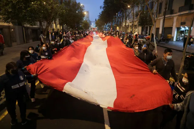 Protestors march with an oversized Peruvian flag against Peru's presidential candidate Keiko Fujimori during a demonstration ahead of the June 6 run-off election between Fujimori and Pedro Castillo, in Lima, Peru on June 1, 2021. (Photo by Sebastian Castaneda/Reuters)