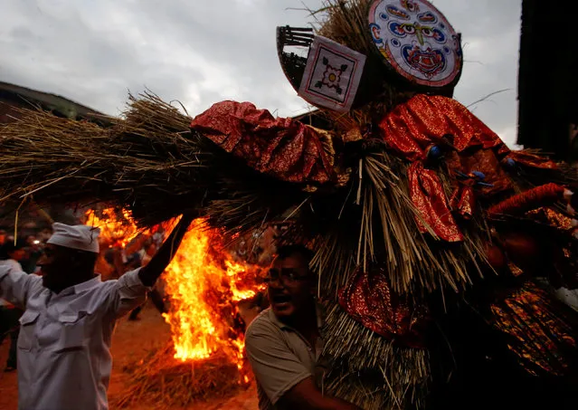 People carry an effigy of the demon Ghantakarna, as another effigy of a demon is burnt to symbolize the destruction of evil and belief to drive evil spirits and ghost, during the Ghantakarna festival at the ancient city of Bhaktapur, Nepal August 9, 2018. (Photo by Navesh Chitrakar/Reuters)