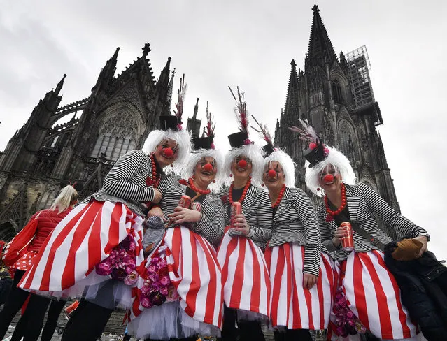 Revellers celebrate in front of the cathedral with tens of thousands the start of the carnival season in the streets of Cologne, Germany, Sunday, November 11, 2018. (Photo by Martin Meissner/AP Photo)