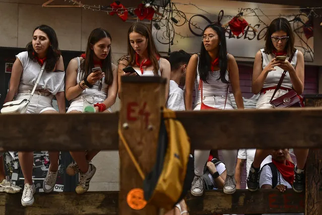 A group of youths wait for the start of the last “encierro” or running of the bulls during the San Fermin festival in Pamplona, northern Spain, Thursday, July 14, 2022. (Photo by Alvaro Barrientos/AP Photo)
